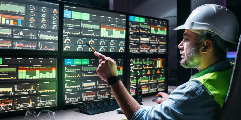 Operator monitoring SCADA and mustering screens in a control room